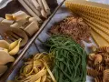 Varietà di pasta cruda, tra cui conchiglioni, paccheri, fettuccine verdi e gialle, lasagne e fusilli, pronte per essere condite con i migliori sughi per pasta.