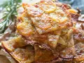 Schiacciata di patate dorata e croccante, con fette sottili di patate e rosmarino.