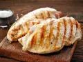 Petto di pollo alla griglia, perfetti secondi di carne da preparare in anticipo. Un contorno di sale completa l'immagine.
