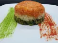 Un colorato timballo di riso a tre strati, con salse verdi e rosse che ricordano i colori di una bandiera.