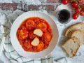 Polpette di ricotta al sugo, morbide e saporite, servite con pane casereccio e pomodorini freschi.