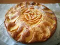 Deliziosa torta di mele senza glutine, decorata con mele a forma di rosa e spolverata di zucchero a velo.