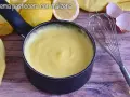 Crema pasticcera con amido di mais, liscia e vellutata, pronta per farcire dolci. Accanto, limoni, frusta e gusci d'uovo.