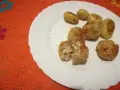 Piatto con polpette di pollo dorate e patate novelle condite. Una polpetta è stata aperta, mostrando l'interno succulento.
