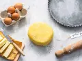 Impasto giallo brillante per una deliziosa pasta frolla senza glutine, pronto con uova, burro e una teglia.