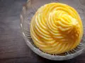 Crema pasticcera ricetta: una deliziosa crema gialla, liscia e lucida, servita in una ciotola di vetro trasparente con decori.