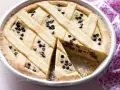 Deliziosa crostata ricotta e cioccolato con un reticolo di pasta frolla e gocce di cioccolato fondente.