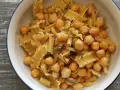 Un piatto invitante di pasta e ceci, con pasta corta e ceci dorati, guarnito con rosmarino fresco.