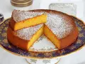 Deliziosa torta carote e mandorle, spolverata di zucchero a velo, servita su un elegante alzata.