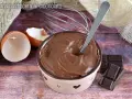 Crema pasticcera al cioccolato, liscia e invitante, pronta per essere gustata. Uova, frusta e cioccolato, ingredienti per un dolce momento.