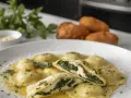 Ravioli ricotta e spinaci in un piatto bianco, conditi con burro fuso e prezzemolo tritato. Uno è tagliato a metà, mostrando il ripieno cremoso.
