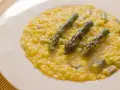 Risotto cremoso con asparagi e zafferano, un piatto primaverile che profuma di sole.