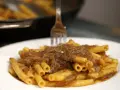Un piatto invitante di ziti alla genovese, con la pasta che abbraccia un ricco ragù di carne e cipolle.