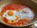 Uova in purgatorio, due uova cotte in una salsa rossa piccante, in una padella.