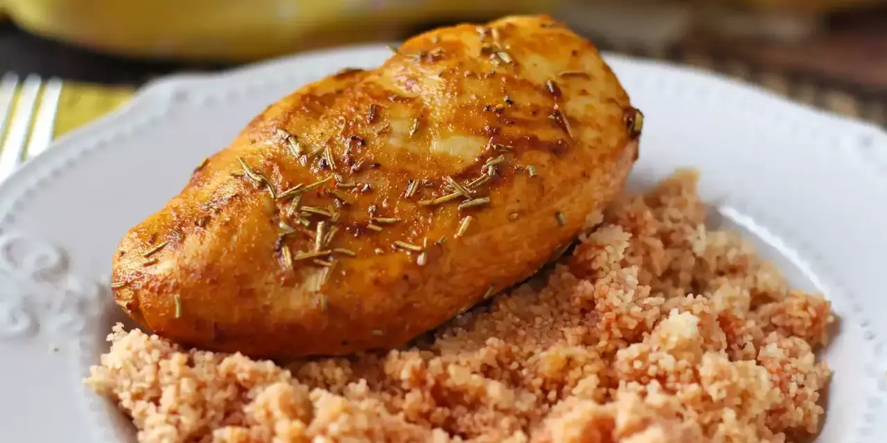 Petto di pollo in friggitrice ad aria, dorato e aromatico, servito su un letto di couscous.