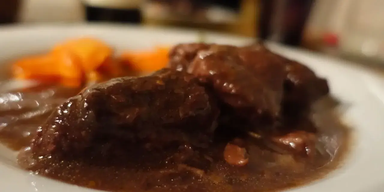 Un succulento brasato al barolo, tenero e saporito, accompagnato da carote arancioni.