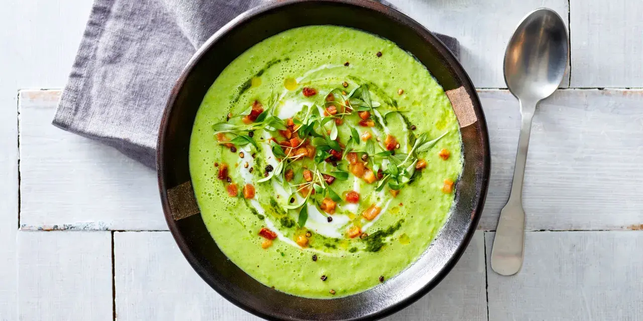 Crema di avocado vellutata, guarnita con cubetti croccanti, erbe fresche e un filo d'olio. Un piatto invitante e salutare.