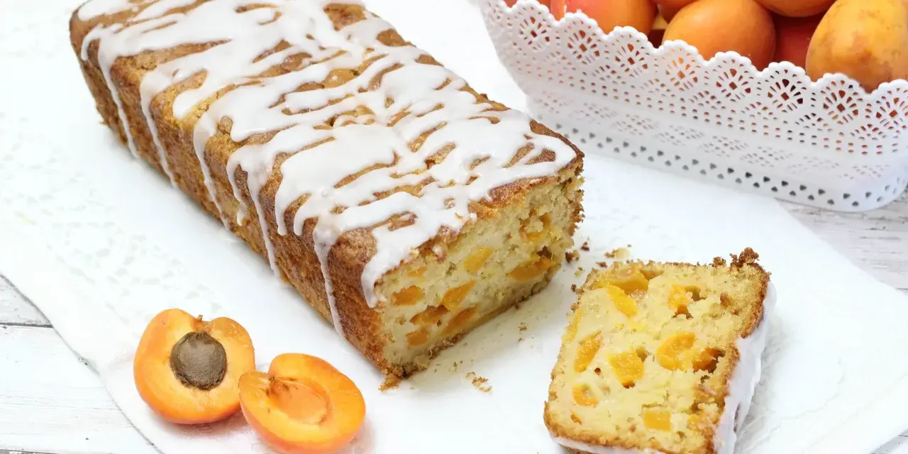 Plumcake senza uova con albicocche fresche, glassato con una leggera copertura bianca. Un dolce soffice e profumato, perfetto per la colazione o la merenda.