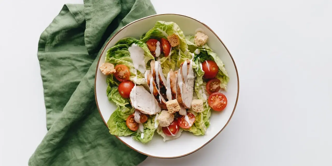 Deliziosa insalata di pollo con lattuga croccante, pomodorini succosi e crostini, condita con una cremosa salsa.