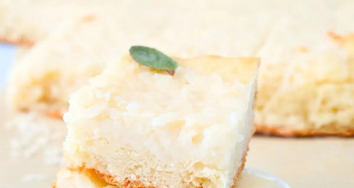 Una fetta di torta di riso carrarina, soffice e profumata, guarnita con una fogliolina verde.