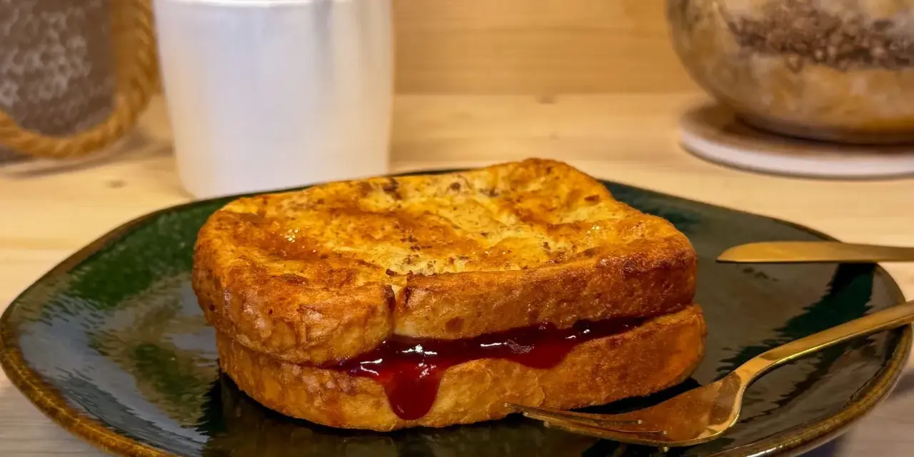 Toast in friggitrice ad aria, dorato e ripieno di marmellata, pronto per essere gustato.