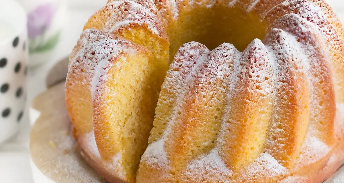 Un soffice ciambellone allo yogurt, cosparso di zucchero a velo, pronto per essere gustato.