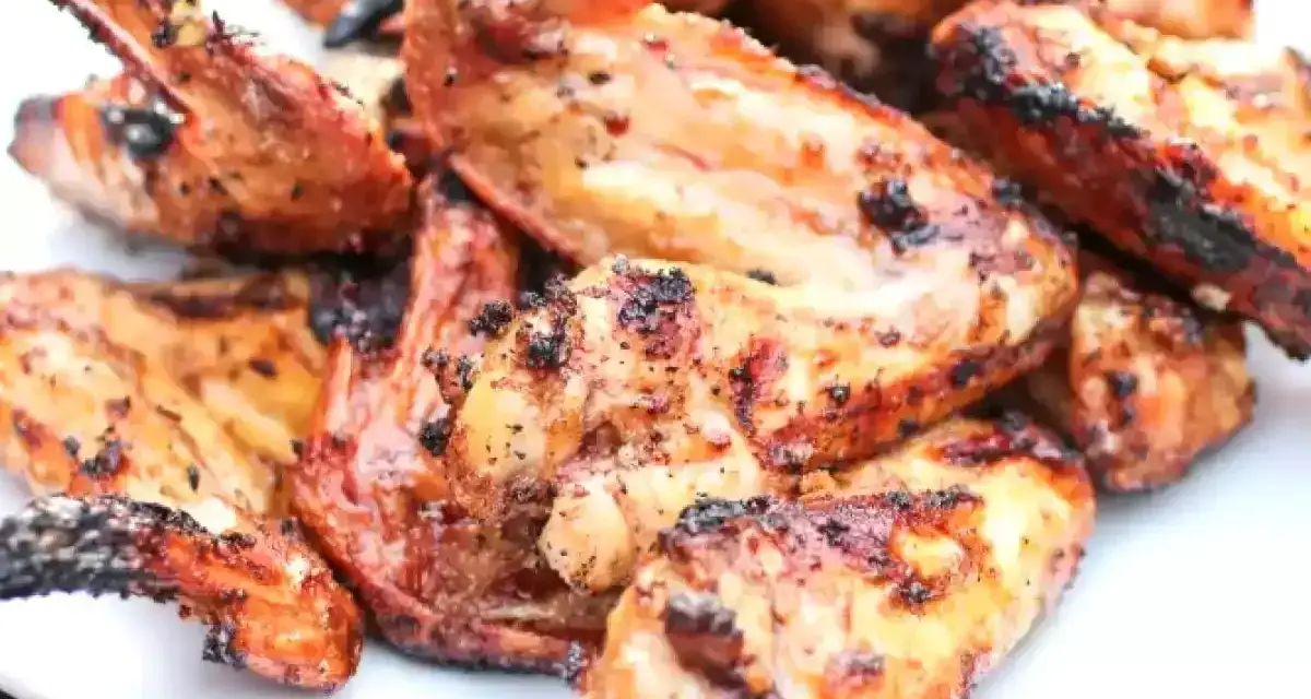 Alette di pollo grigliate, dorate e succulente, pronte per essere gustate.