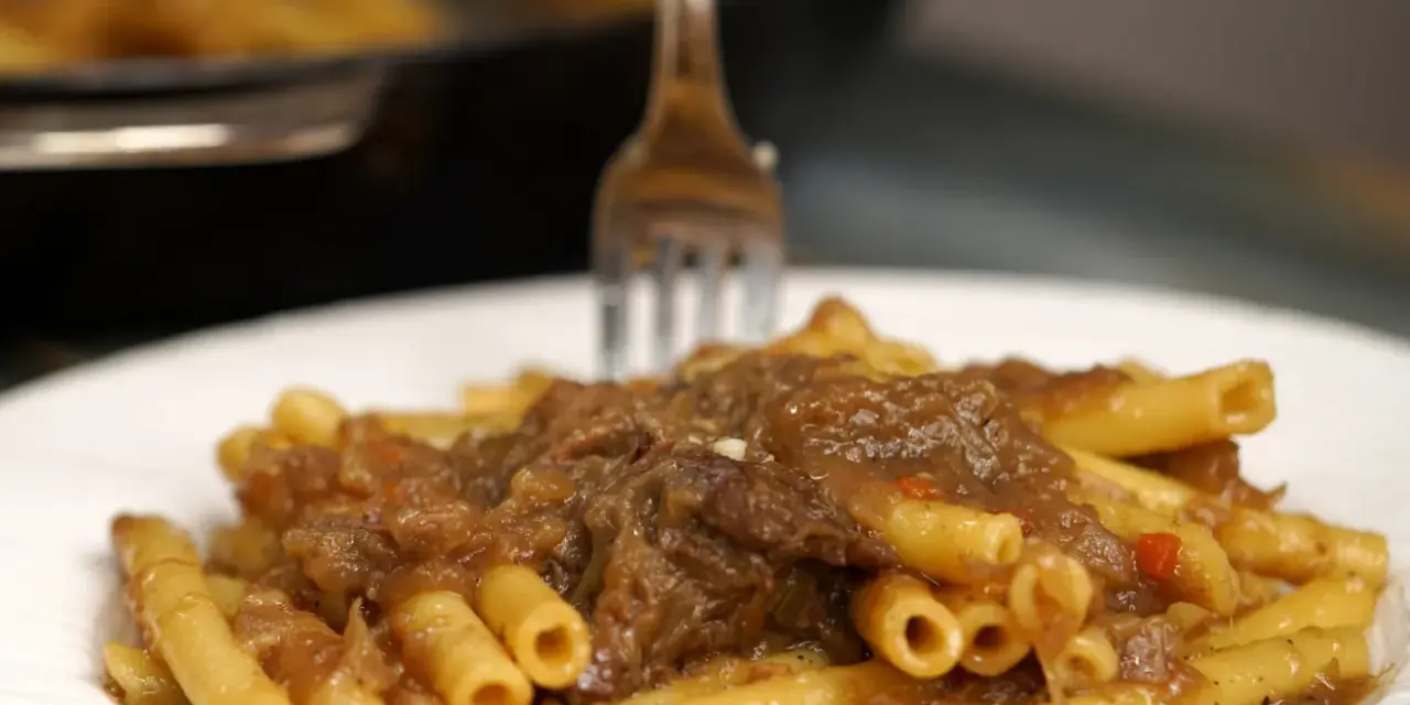 Un piatto invitante di ziti alla genovese, con la pasta che abbraccia un ricco ragù di carne e cipolle.
