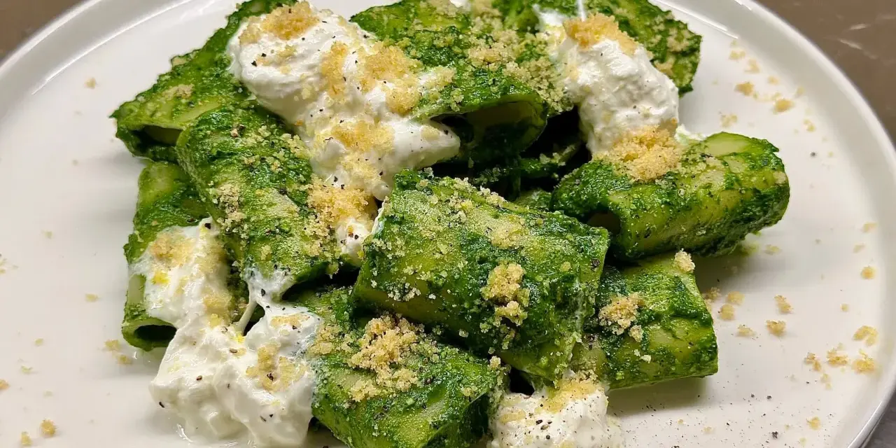 Paccheri conditi con un vibrante pesto di cavolo nero, arricchiti da ricotta fresca e pangrattato croccante.