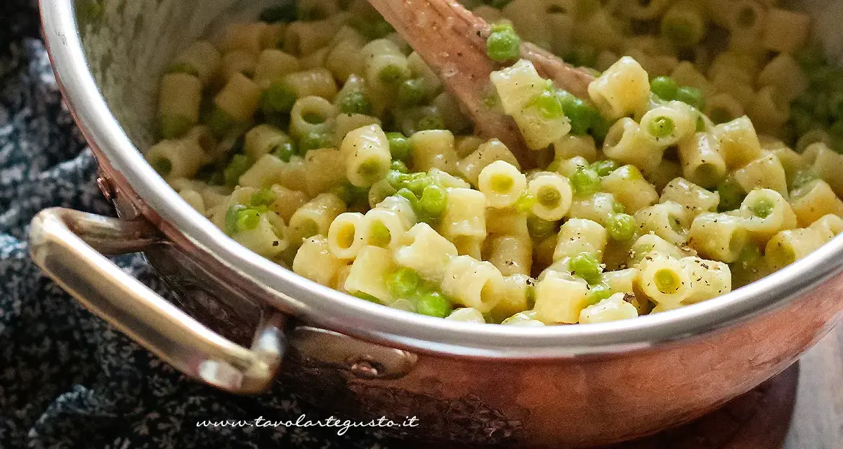 Un primo piatto cremoso di pasta e piselli, pronto per essere gustato.