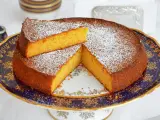 Deliziosa torta carote e mandorle, spolverata di zucchero a velo, servita su un elegante alzata.