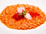Un cremoso risotto al pomodoro, guarnito con calamari teneri, pomodorini e germogli freschi. Un piatto che celebra i sapori dell'Italia.