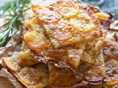 Schiacciata di patate dorata e croccante, con fette sottili di patate e rosmarino.