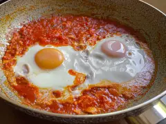 Uova in purgatorio, due uova cotte in una salsa rossa piccante, in una padella.