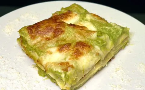 Lasagne con asparagi e speck, un piatto invitante con strati dorati e un ripieno verde brillante.