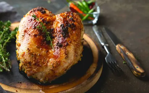 Petto di pollo al forno dorato e succulento, condito con senape e erbe aromatiche, pronto per essere gustato.