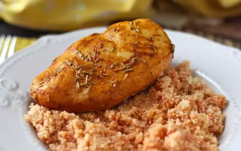 Petto di pollo in friggitrice ad aria, dorato e aromatico, servito su un letto di couscous.