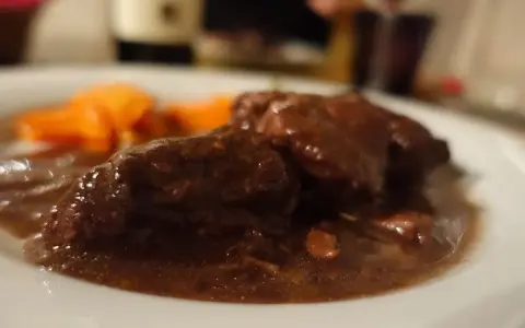 Un succulento brasato al barolo, tenero e saporito, accompagnato da carote arancioni.