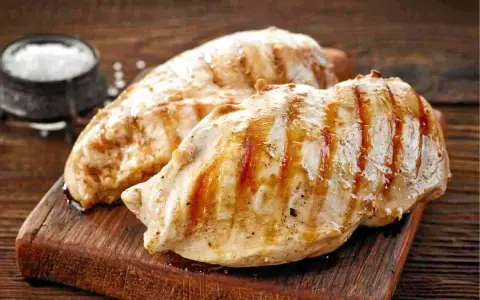 Petto di pollo alla griglia, perfetti secondi di carne da preparare in anticipo. Un contorno di sale completa l'immagine.