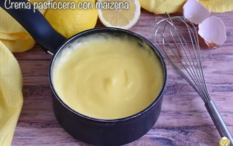 Crema pasticcera con amido di mais, liscia e vellutata, pronta per farcire dolci. Accanto, limoni, frusta e gusci d'uovo.