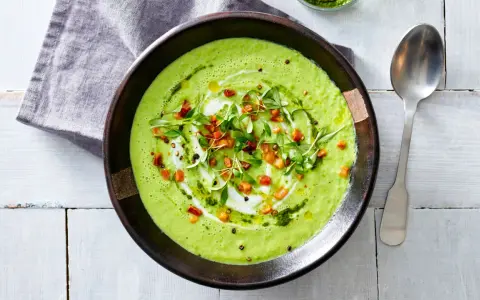 Crema di avocado vellutata, guarnita con cubetti croccanti, erbe fresche e un filo d'olio. Un piatto invitante e salutare.