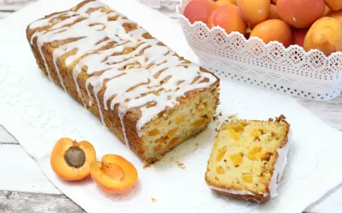 Plumcake senza uova con albicocche fresche, glassato con una leggera copertura bianca. Un dolce soffice e profumato, perfetto per la colazione o la merenda.