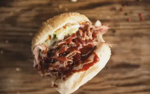 Un panino succulento con pulled pork, salsa barbecue e insalata di cavolo, perfetto per chi cerca una ricetta facile e gustosa.