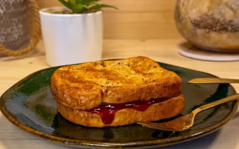 Toast in friggitrice ad aria, dorato e ripieno di marmellata, pronto per essere gustato.