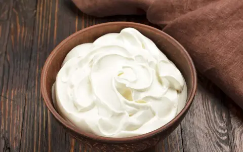 Una ciotola di panna da cucina, soffice e cremosa, pronta per arricchire ogni piatto.
