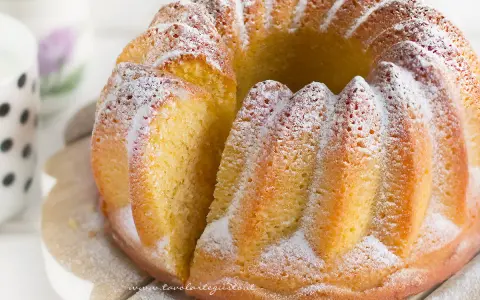 Un soffice ciambellone allo yogurt, cosparso di zucchero a velo, pronto per essere gustato.
