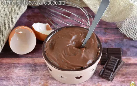 Crema pasticcera al cioccolato, liscia e invitante, pronta per essere gustata. Uova, frusta e cioccolato, ingredienti per un dolce momento.