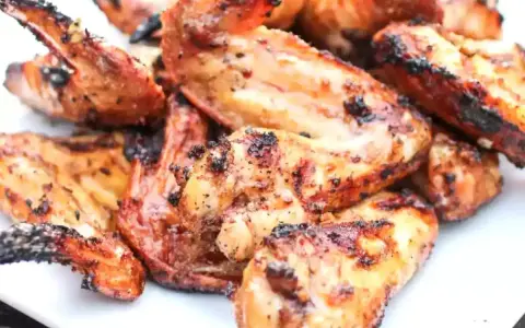 Alette di pollo grigliate, dorate e succulente, pronte per essere gustate.