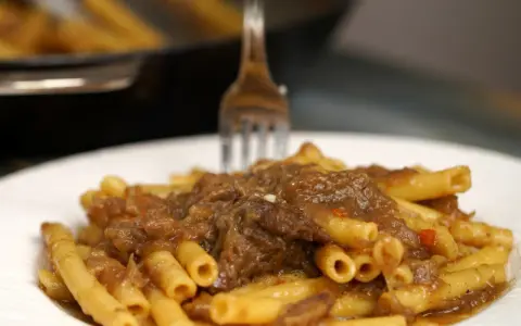 Un piatto invitante di ziti alla genovese, con la pasta che abbraccia un ricco ragù di carne e cipolle.