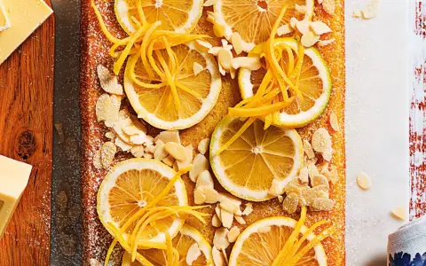 Torta soffice con fette di limone, scorza candita e mandorle a lamelle. Un'esplosione di freschezza per la tua caprese al limone.